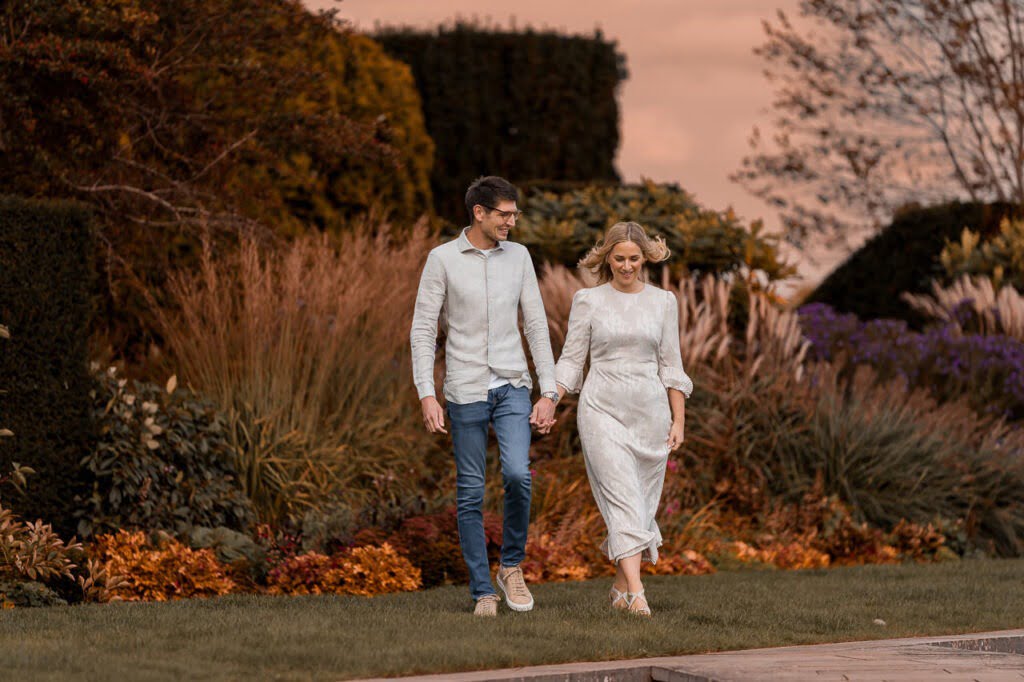 couple walking around the gardens for their summer engagement