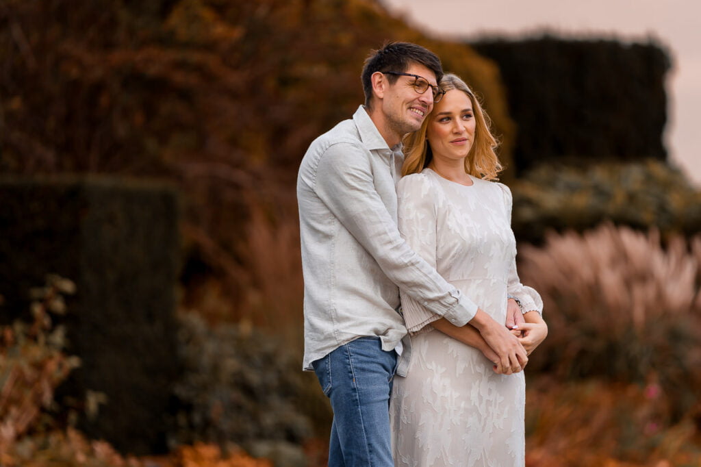 engaged couple standing together looking at at the field at the grove hotel