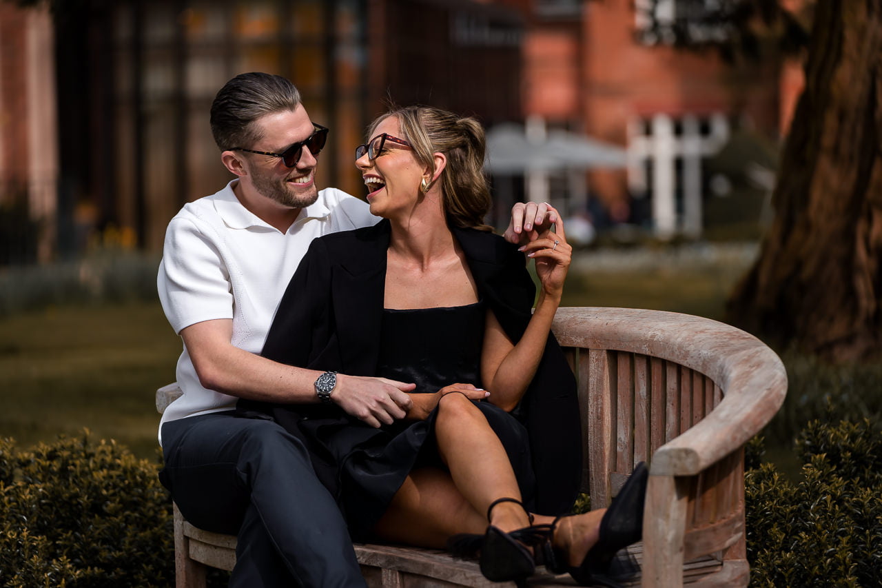 engaged couple sitting on a wooden bench for a spring engagement shoot at the Grove Hotel