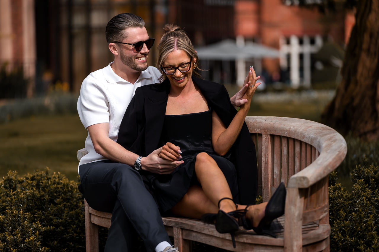 couple sitting on a wooden bench for a spring engagement shoot at the Grove Hotel