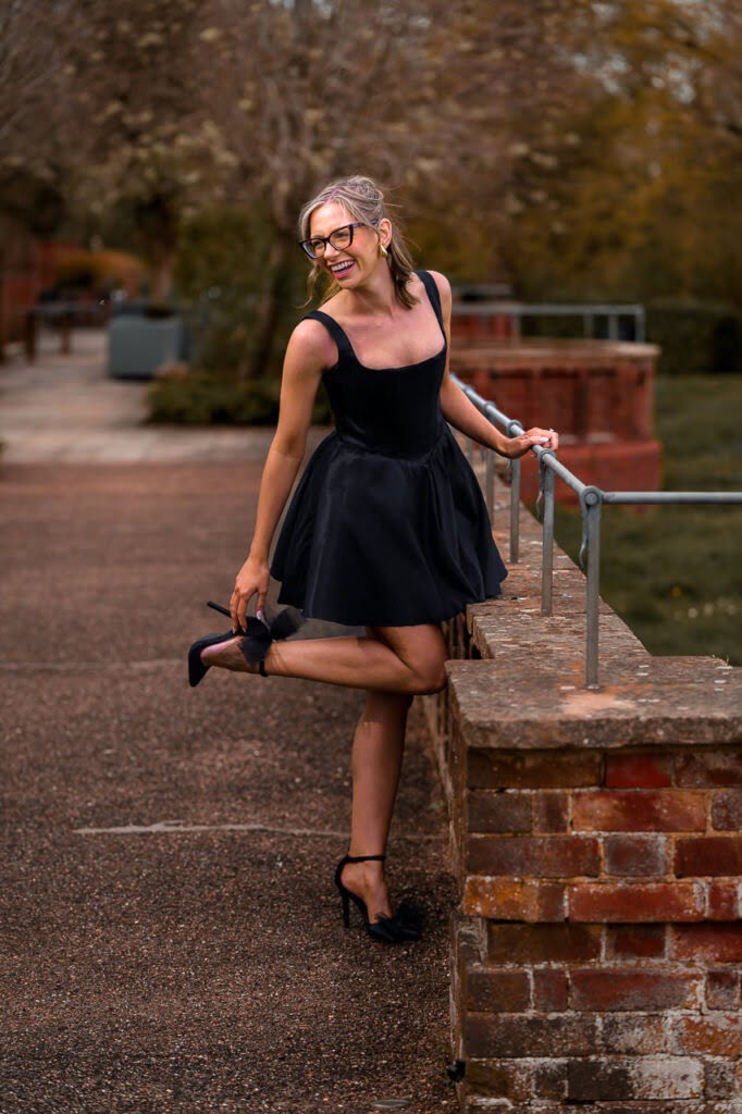 portrait of a bride with a black dress and high heels in the gardens of the Grove Hotel