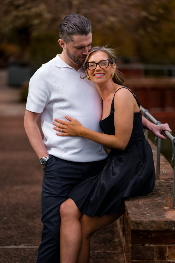 couple cuddling together on a wall in the gardens