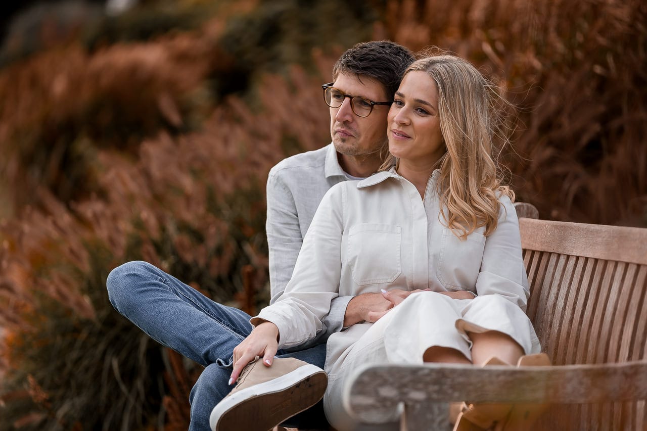 couple sitting on a wooden bench in the gardens of the Grove Hertfordshire