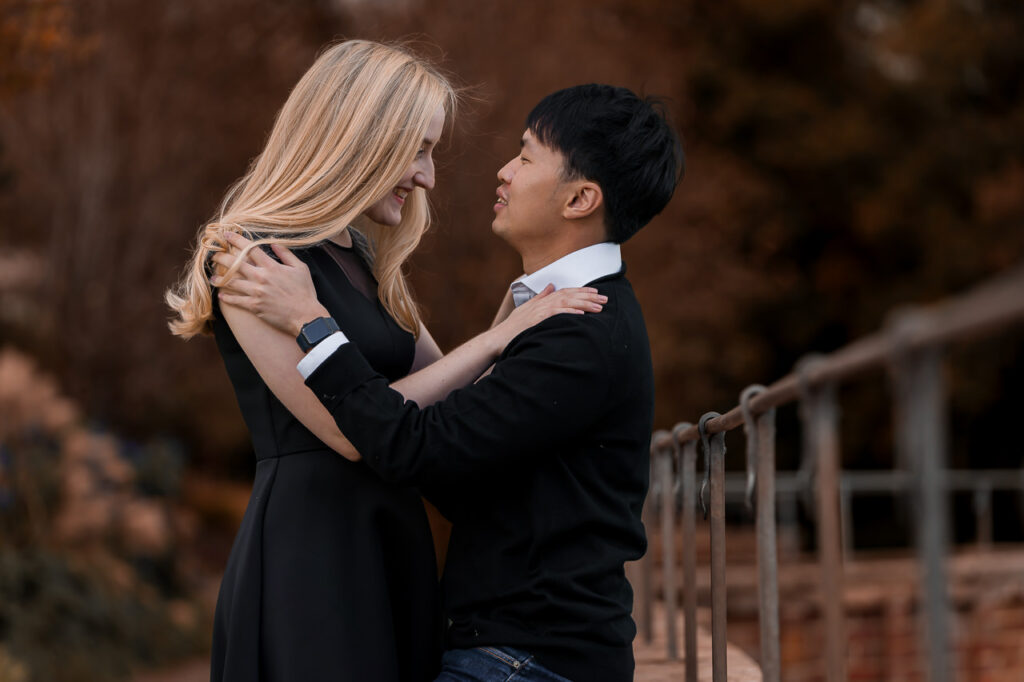couple sitting on a wall and looking at each other